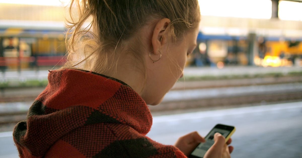 Ілюстративне фото: підліток зі смартфоном уночі на тлі цифрового простору